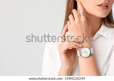 Woman with stylish wrist watch on white background Royalty-Free Stock Photo #1984226249