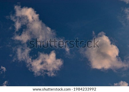 white clouds blown by the winds dissolving under the blue sky.