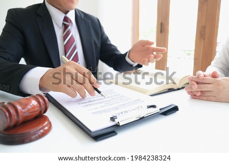 Partner lawyers or attorneys discussing a contract agreement. Successful businessmen hand putting signing contract,have a contract in place to protect it,signing of modest agreements form in office.
