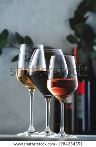 Wines assortment. Red, white, rose wine in wineglasses and bottles on gray background. Wine bar, shop, tasting concept Royalty-Free Stock Photo #1984254551