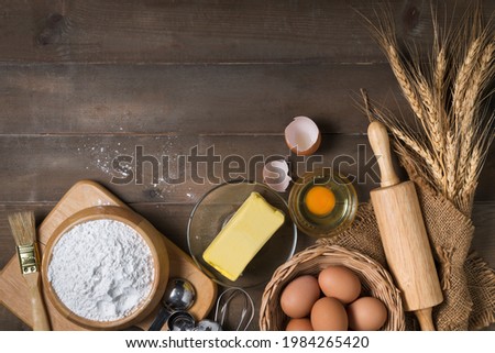 Bread flour with fresh egg, Unsalted butter and accessories bakery on wood background, prepare for homemade bakery concept Royalty-Free Stock Photo #1984265420