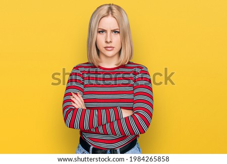 Young blonde woman wearing casual clothes skeptic and nervous, disapproving expression on face with crossed arms. negative person. 