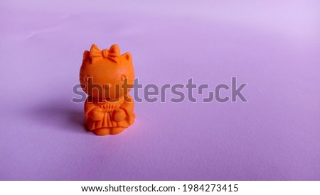 Photo of cute little doll replica on pink background