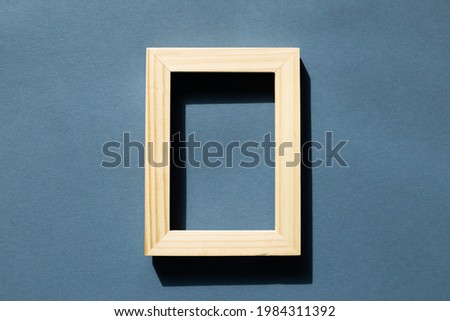 Wooden picture frame on navy blue background. top view, copy space
