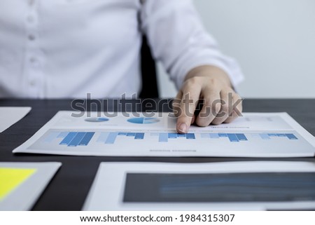 Close-up pressing a white calculator, a female auditor using a calculator to verify the accuracy of company financial numbers to summarize attendance at a monthly meeting. Accounting auditing concept.