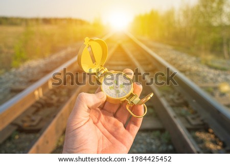 Compass in hand on the background railroad. Concept of travel by train, trip, tourism