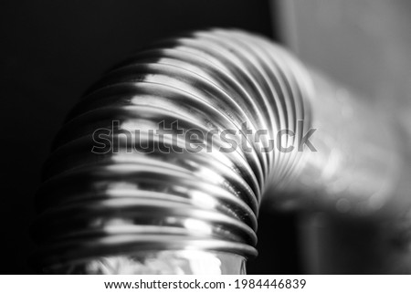 Close-up of steel pipe with round corner on black background. Black and white photo.
