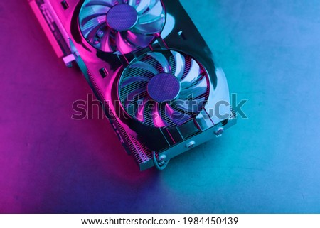 Gaming graphics card with neon magenta-cyan illumination and high-speed fans.