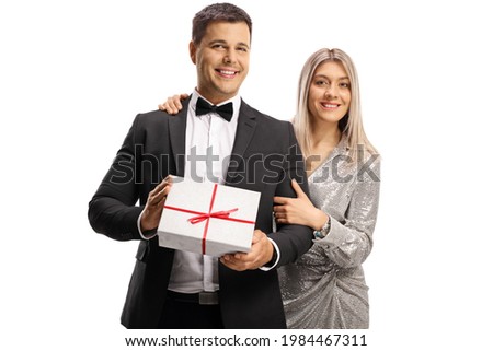 Young man and woman in elegant clothes holding a present box isolated on white background