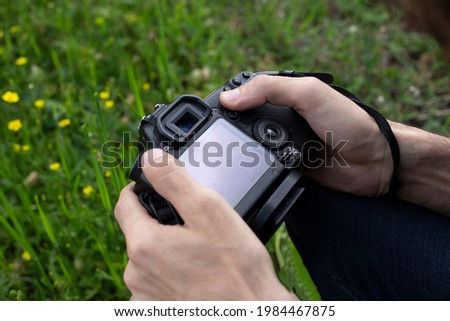 Close up, man photographer holding digital camera