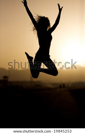 Photo jumping up a young girl at dawn. Evening road.
