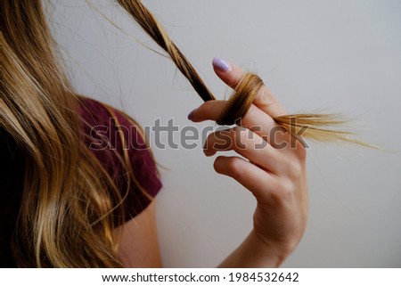 Girl twisting and twirling her hair Royalty-Free Stock Photo #1984532642