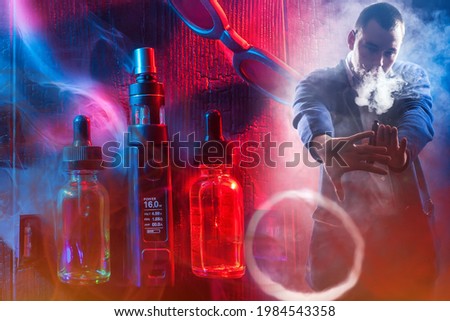 Red and blue concept of vaping. The man blows a smoke ring from an e-cigarette and gestures. Vaper and VAPE accessories. A man demonstrates the steam from an e-cigarette.