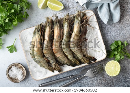raw black tiger prawns on ice on a concrete background, top view, selective focus