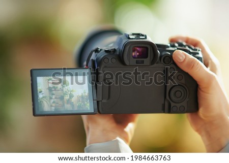 Interior videography. Closeup on modern woman with mirrorless camera at modern home in sunny day. Royalty-Free Stock Photo #1984663763