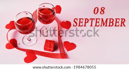 calendar date on light background with two glasses of red wine, red gift box and red hearts with copy space. September 8 is the eighth day of the month.
