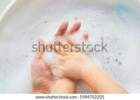 Women's and children's hands in white foam. Hygiene and cleanliness, skin care. High quality photo