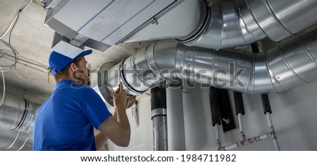 hvac worker install ducted pipe system for ventilation and air conditioning. copy space Royalty-Free Stock Photo #1984711982