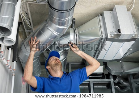 hvac services - worker install ducted pipe system for ventilation and air conditioning in house Royalty-Free Stock Photo #1984711985