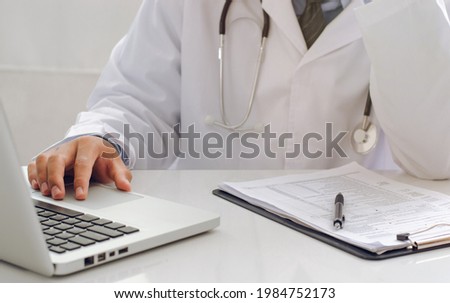 A young doctor who is worried about his medical career at work. with laptop notebook A highly thoughtful male therapist is worried about solving drug problems.