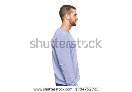 Young caucasian man wearing casual clothes looking to side, relax profile pose with natural face with confident smile. 