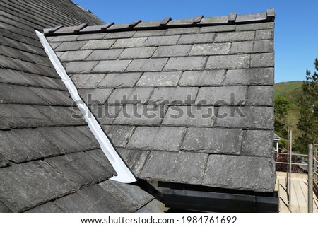 A close up view of a slate roof over a dormer window on a house in Wales, UK. Royalty-Free Stock Photo #1984761692