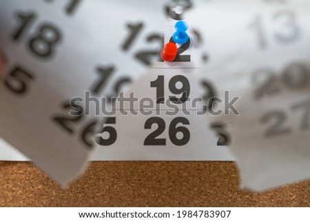 In the foreground a torn calendar, in the background a calendar with the days marked