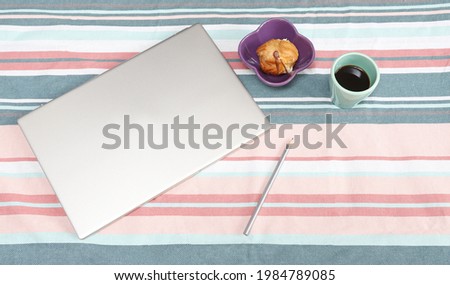 Modern home office or work place with laptop, pencil, coffee and sweets