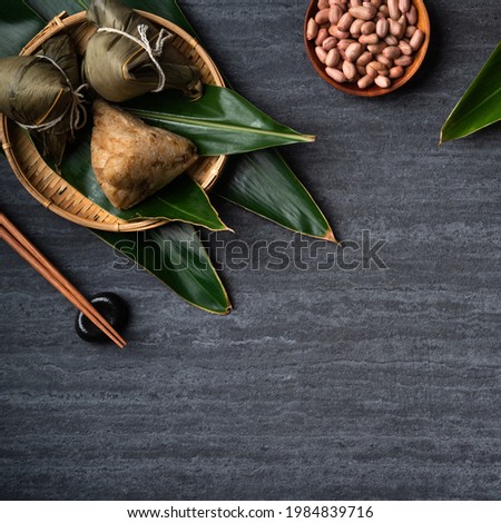 Zongzi. Rice dumpling top view design concept for Chinese traditional Dragon Boat Festival (Duanwu Festival) over dark black slate background.