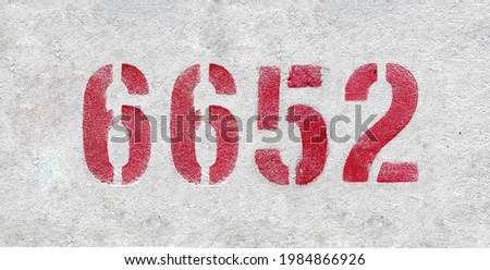 Red Number 6652 on the white wall. Spray paint.