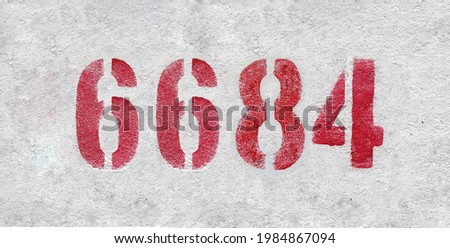 Red Number 6684 on the white wall. Spray paint.