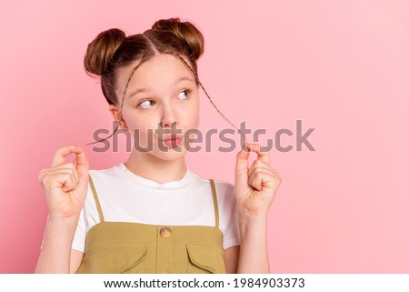 Portrait of attractive funky minded pre-teen girl thinking copy space pout lips isolated over pink pastel color background
