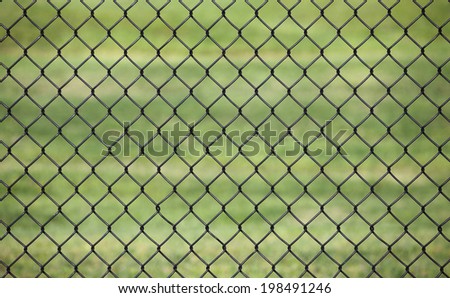 Metal fence with Green grass field background for protection, use as the background