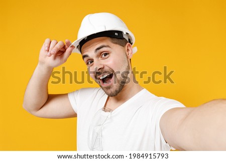 Close up young employee handyman man in protective helmet do selfie shot on mobile phone tip hardhat isolated on yellow background Instruments accessories renovation apartment room Repair home concept