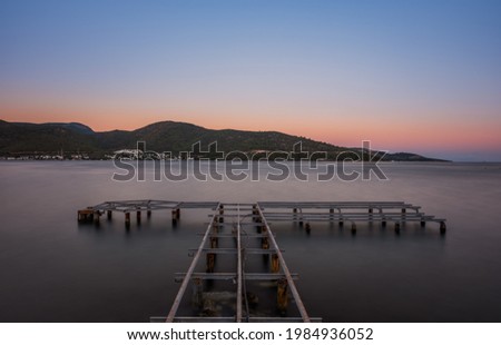 sunset over bay in Aegean sea. Torba, Bodrum, Turkey. October 2020. Long exposure picture with pier, jetty