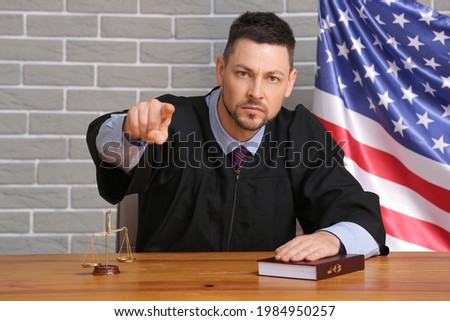Strict male judge at table in courtroom