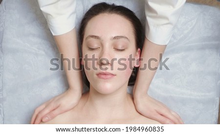 Photo of young woman gets a facial massage in clinic