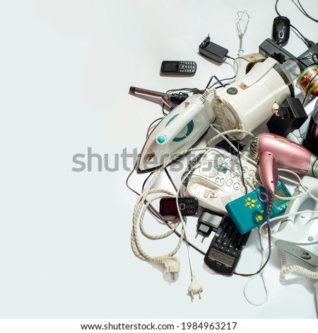 Lots of old electrical appliances for recycling e-waste. Sustainable living concept. Space for text on white background Royalty-Free Stock Photo #1984963217