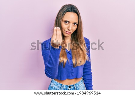 Beautiful hispanic woman wearing casual blue shirt doing italian gesture with hand and fingers confident expression 