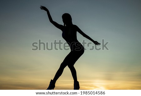 Become the ultimate dancer. Woman ballet dancer in dusk. Dance girl silhouette on evening sky