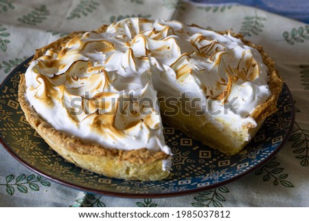 Homemade lemon meringue pie that has just been cut.