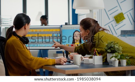 Team of women retouchers working with modern photo editing software app in digital multimedia company, discussing and taking notes. Art director consulting designer colleague, retouching portrait