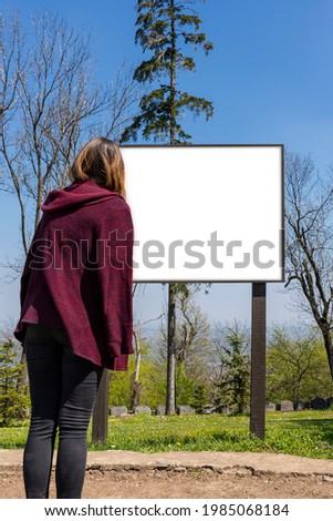 Woman looking at signboard with white blank board for copy space. Add text, photo, information