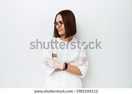 Beautiful female doctor looking away while posing on camera over white background with copy space Royalty-Free Stock Photo #1985104112