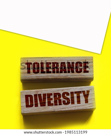 Tolerance diversity words on wooden blocks on yellow. Equality concept by gender, ethnicity and age.