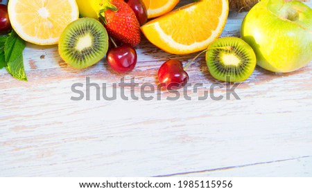Assorted juicy fruits and ripe berries on a wooden background