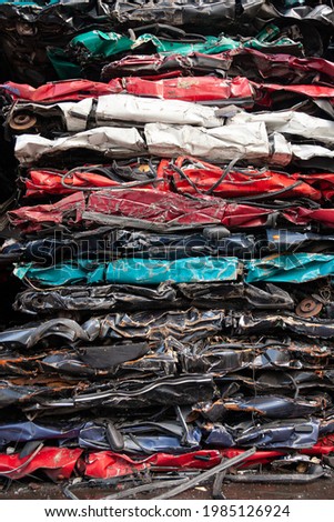 Compacted vehicles as a stack in different colors from a car recycling center  Royalty-Free Stock Photo #1985126924