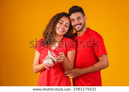 Portrait of a beautiful couple  on yellow background with a gift