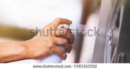 hands of a person with spray paint Royalty-Free Stock Photo #1985263502