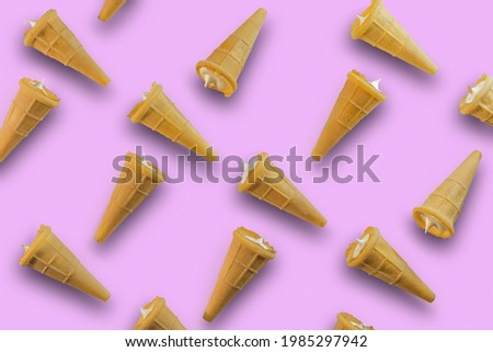 Waffle cones with white sweet filling on a pink background. Sweet waffle cones with filling. The image of a sweet treat.